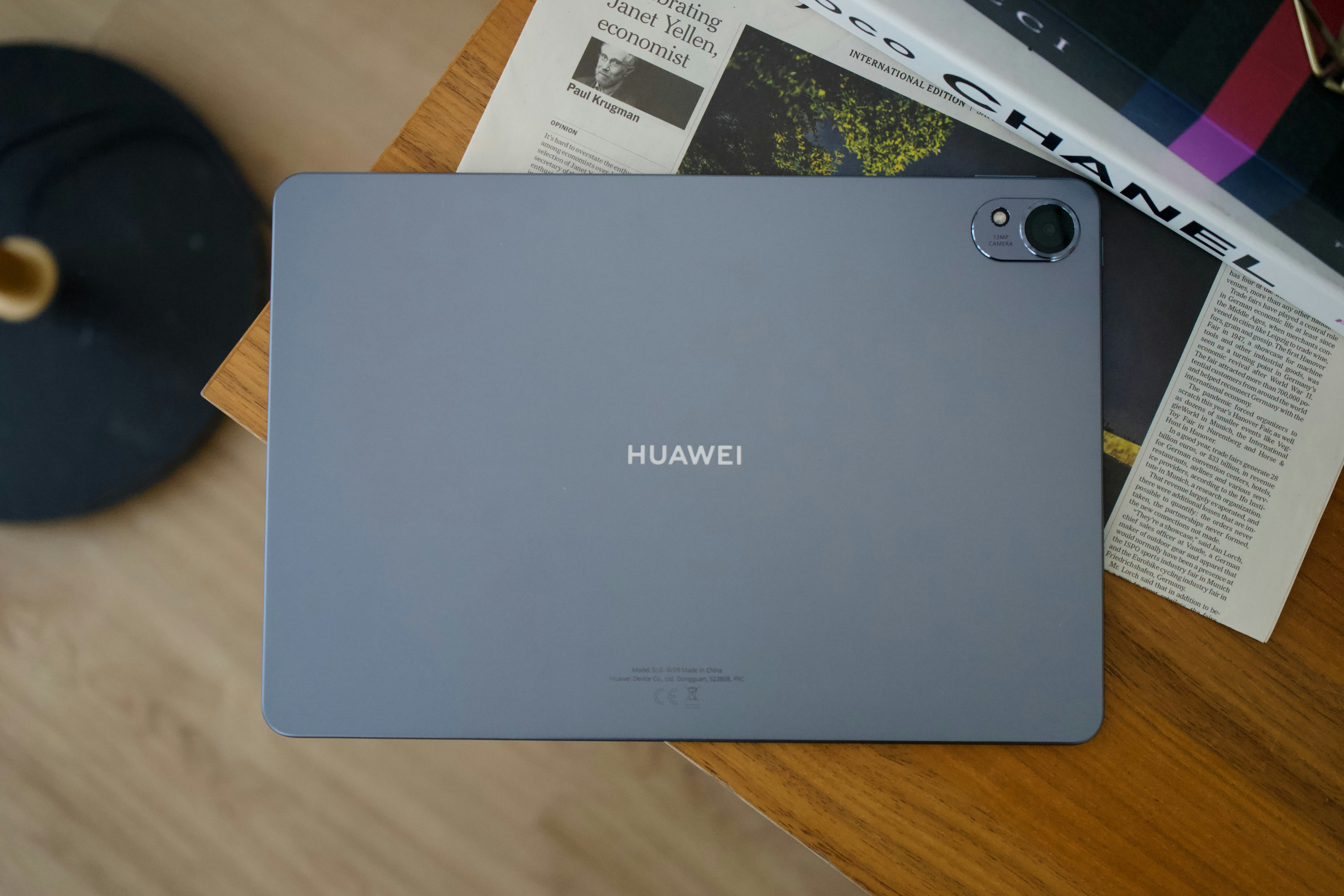 Gray huawei tablet lying on a wooden table.