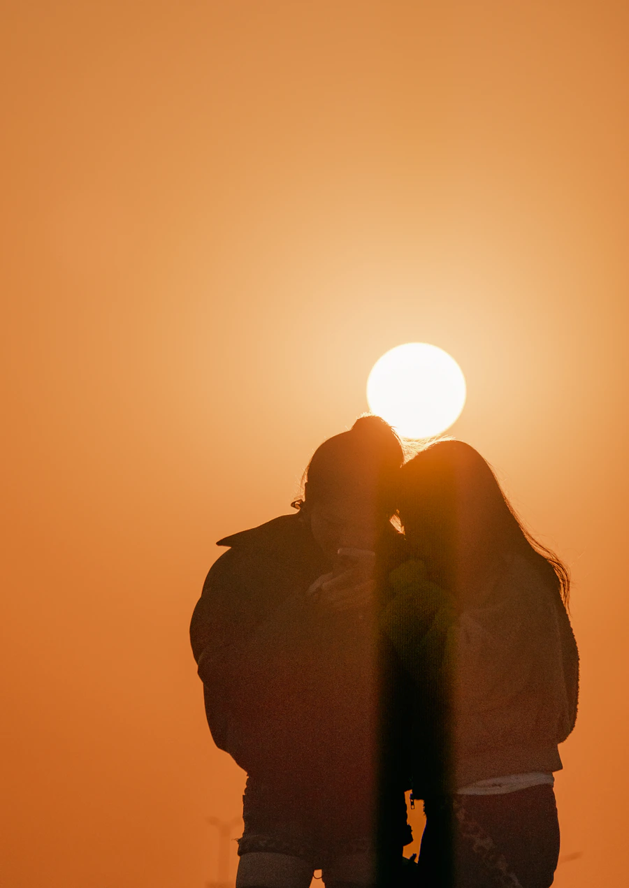 Couple silhouetted at a golden sunset