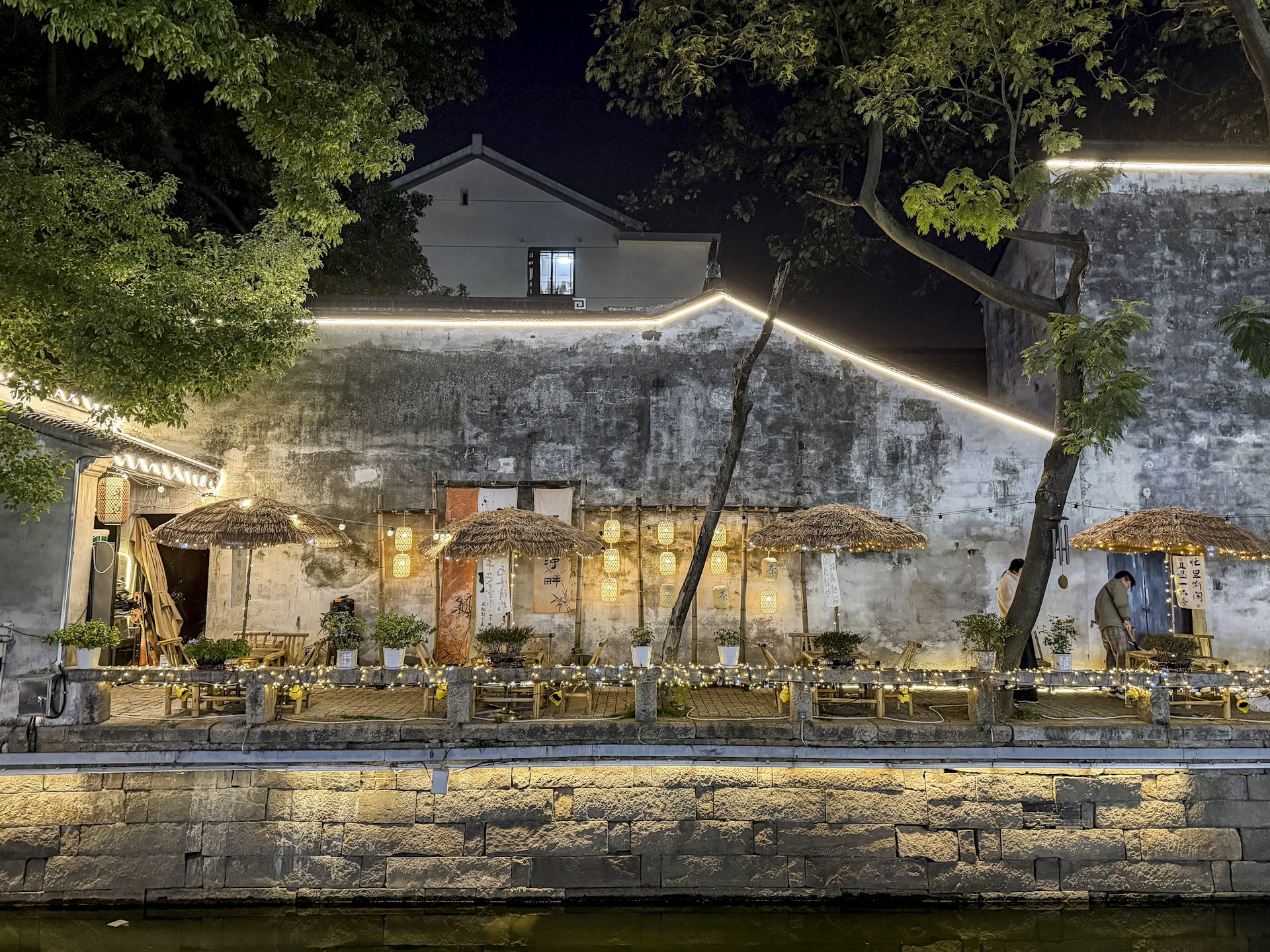 Waterside restaurant with warm lighting reflected on the river at dusk