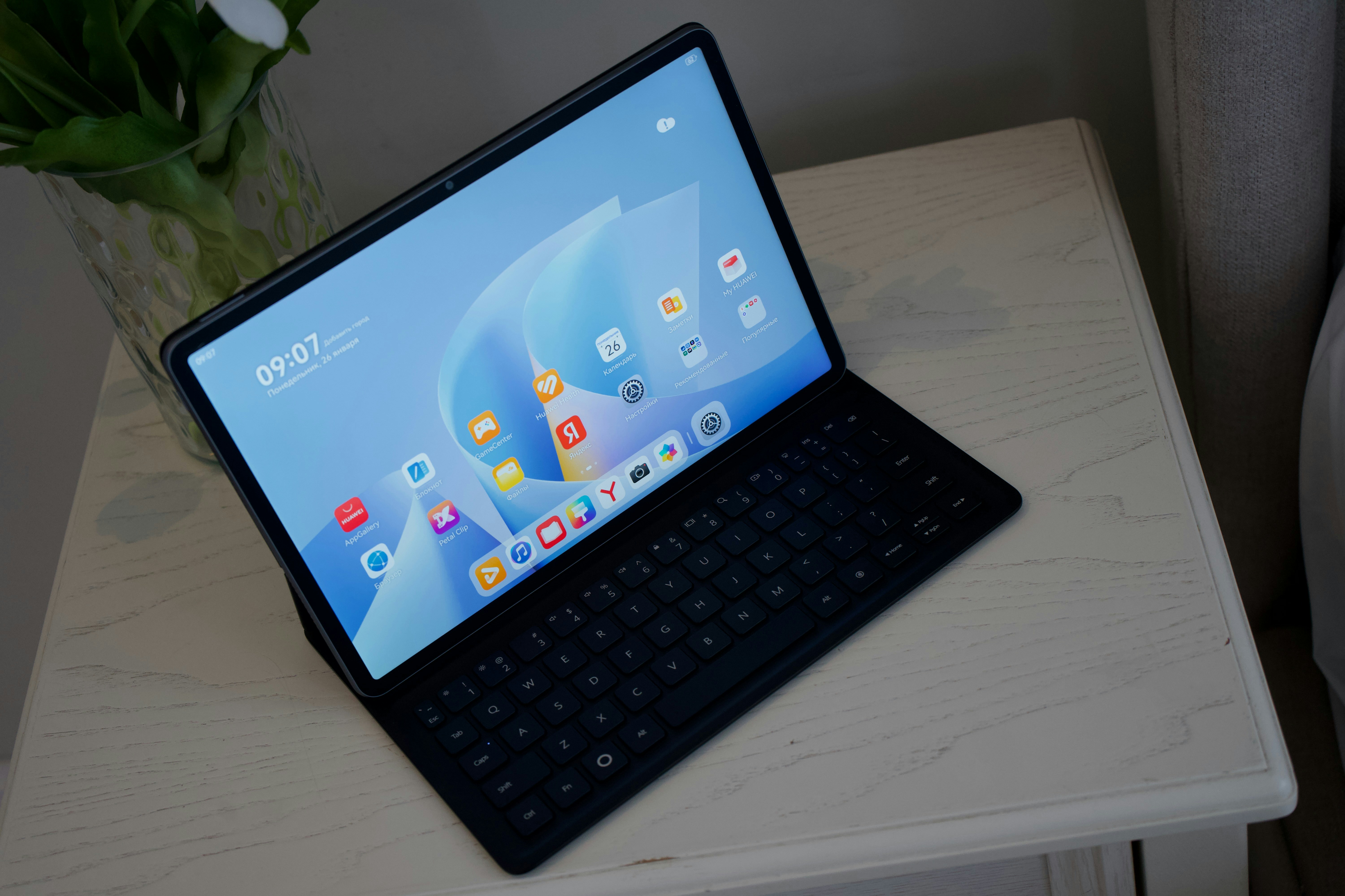 A tablet with a keyboard case on a table.