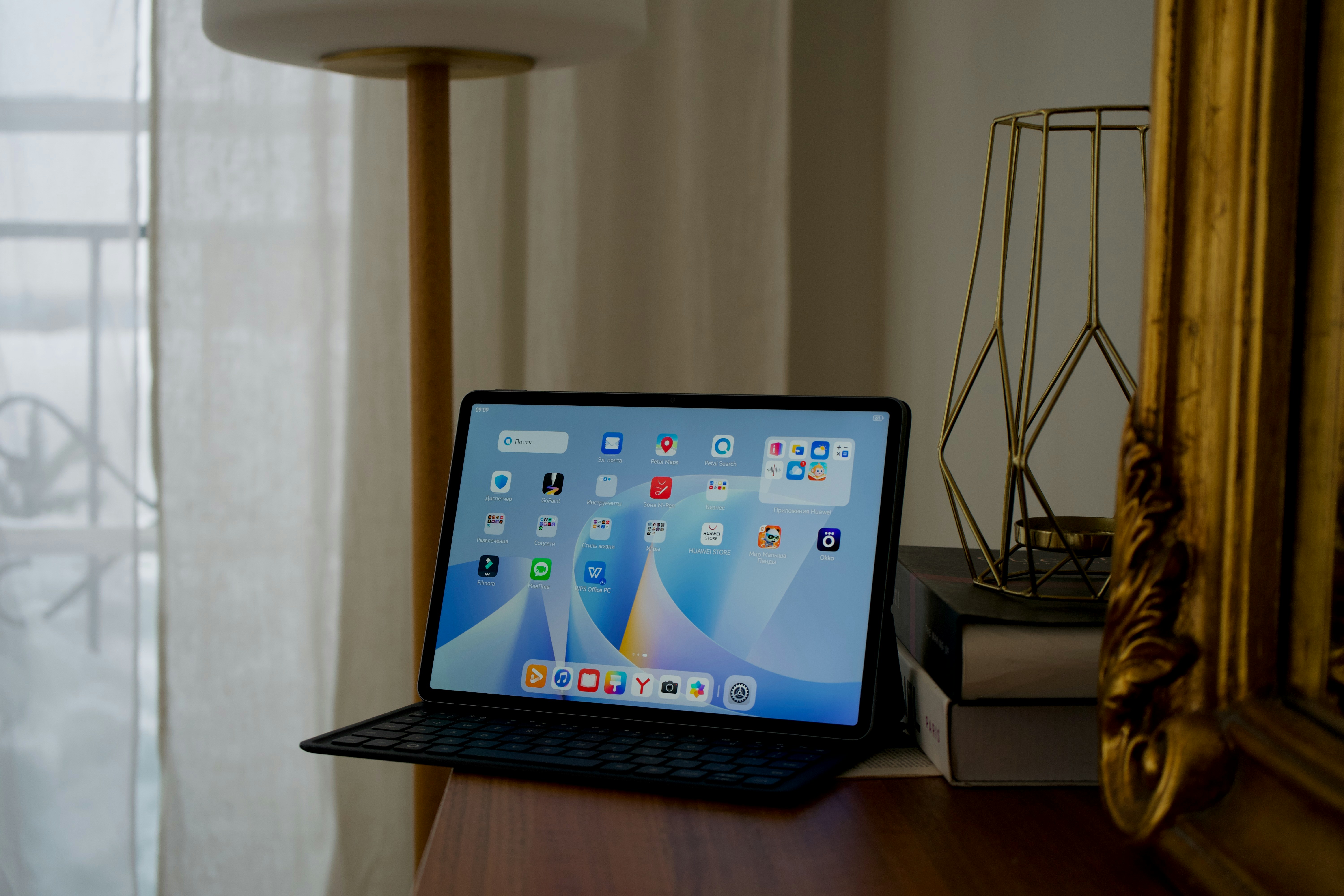 Tablette avec clavier posé sur un bureau près de la fenêtre.