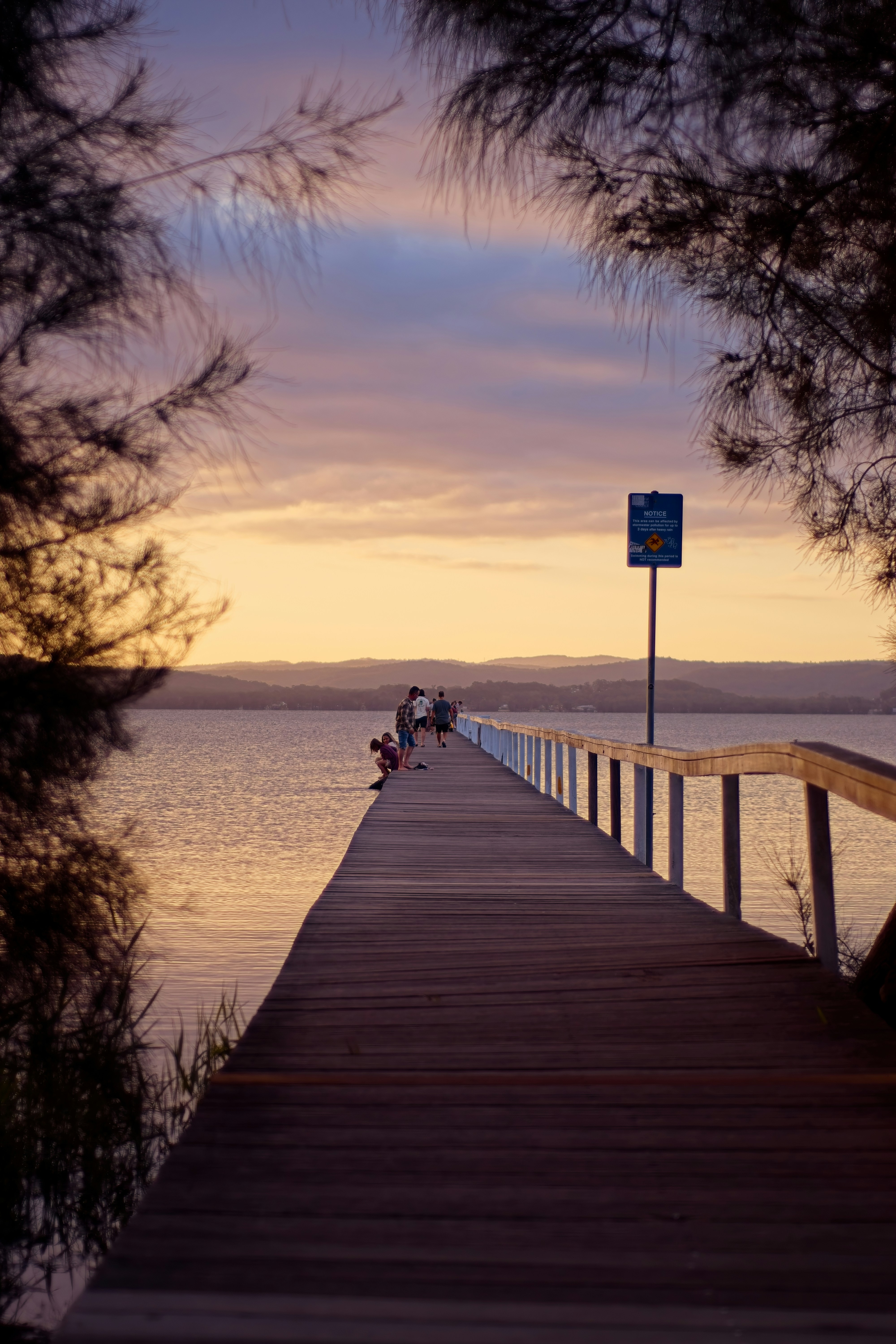 Persone che camminano su un molo al tramonto