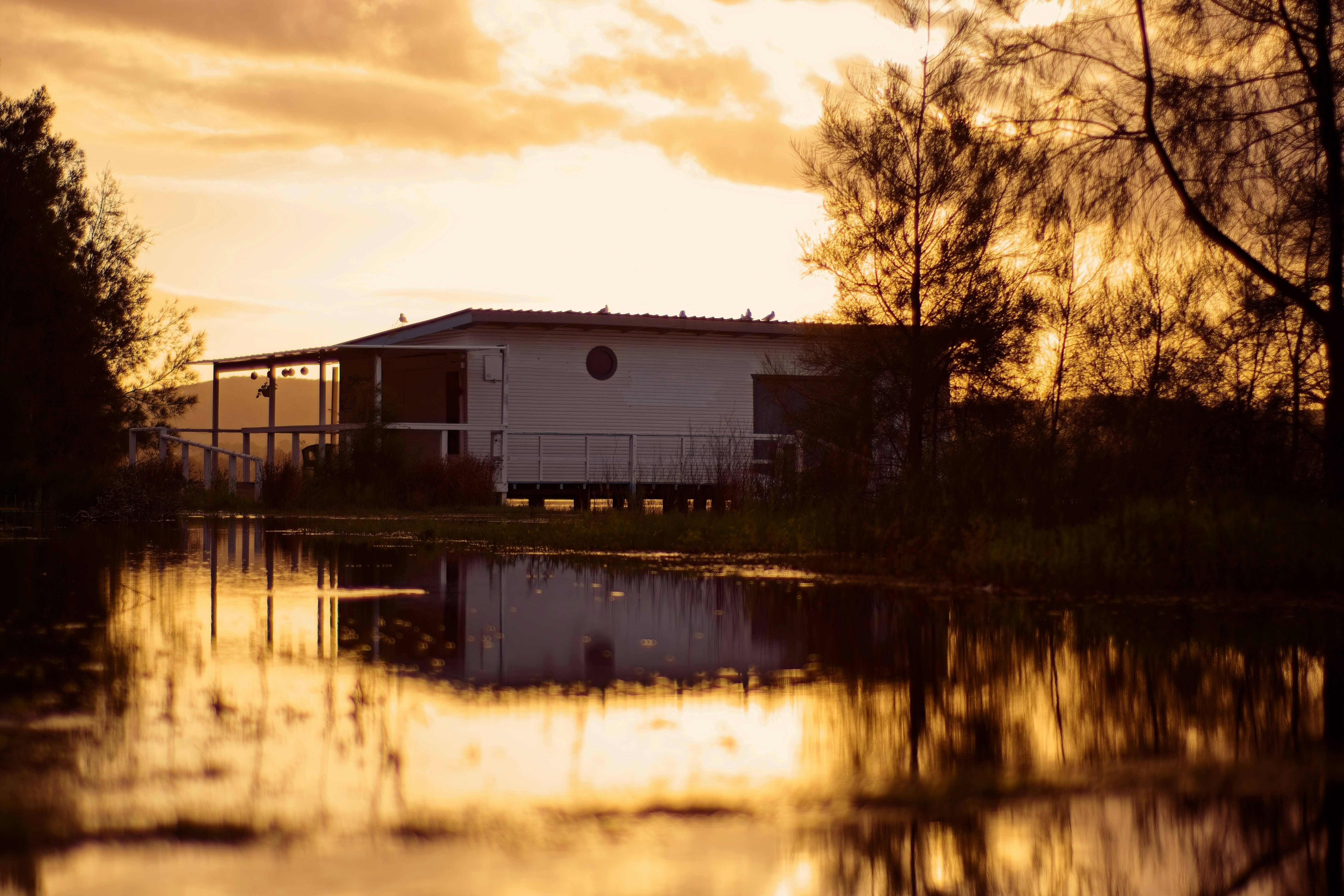 Una casa bianca riflessa nell'acqua al tramonto