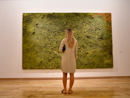 Woman observing a large abstract green painting
