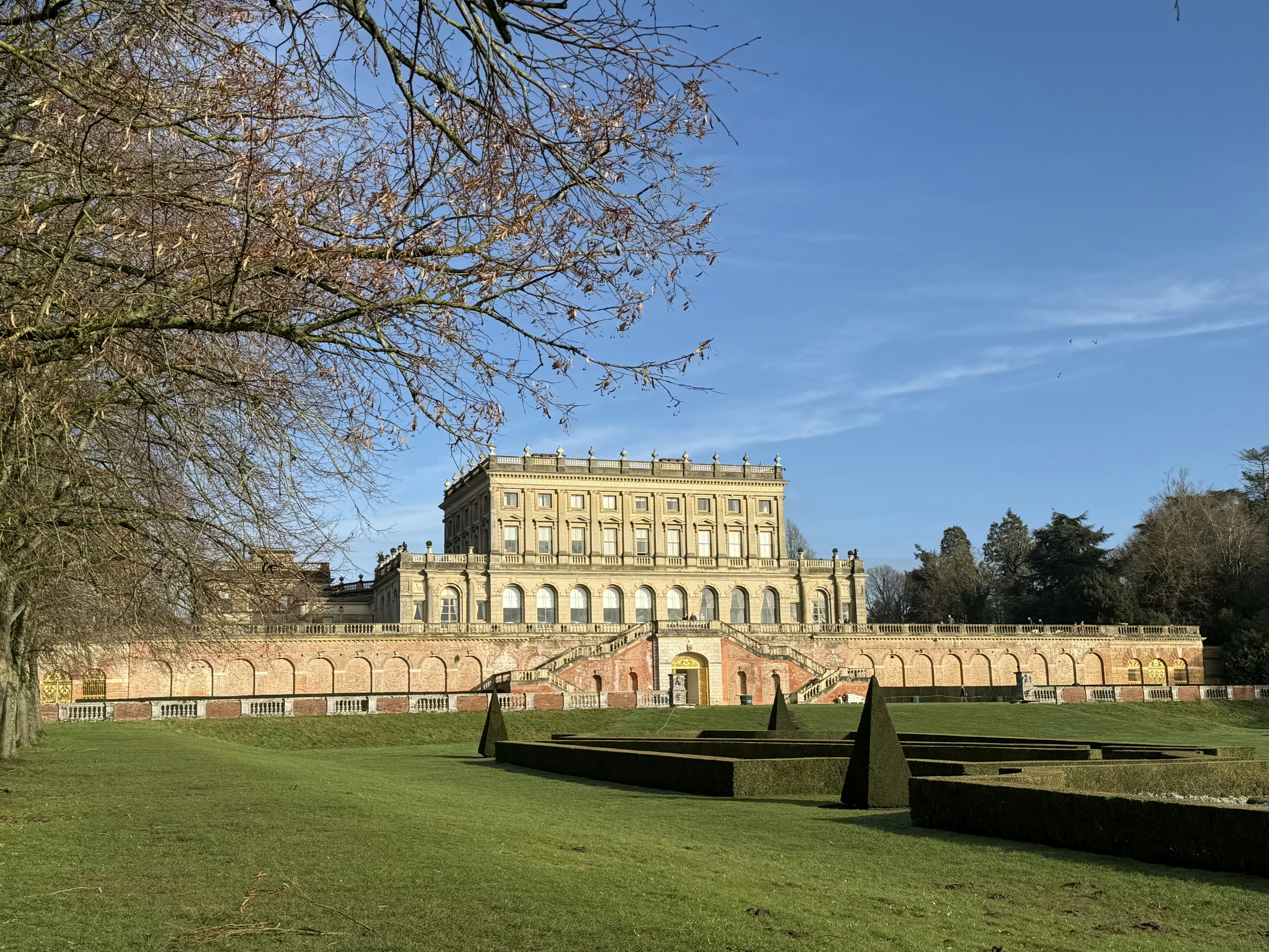 Grande demeure seigneuriale avec jardins à la française sous un ciel dégagé