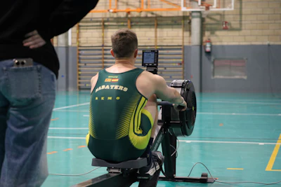 Man rowing on a machine in a gym.