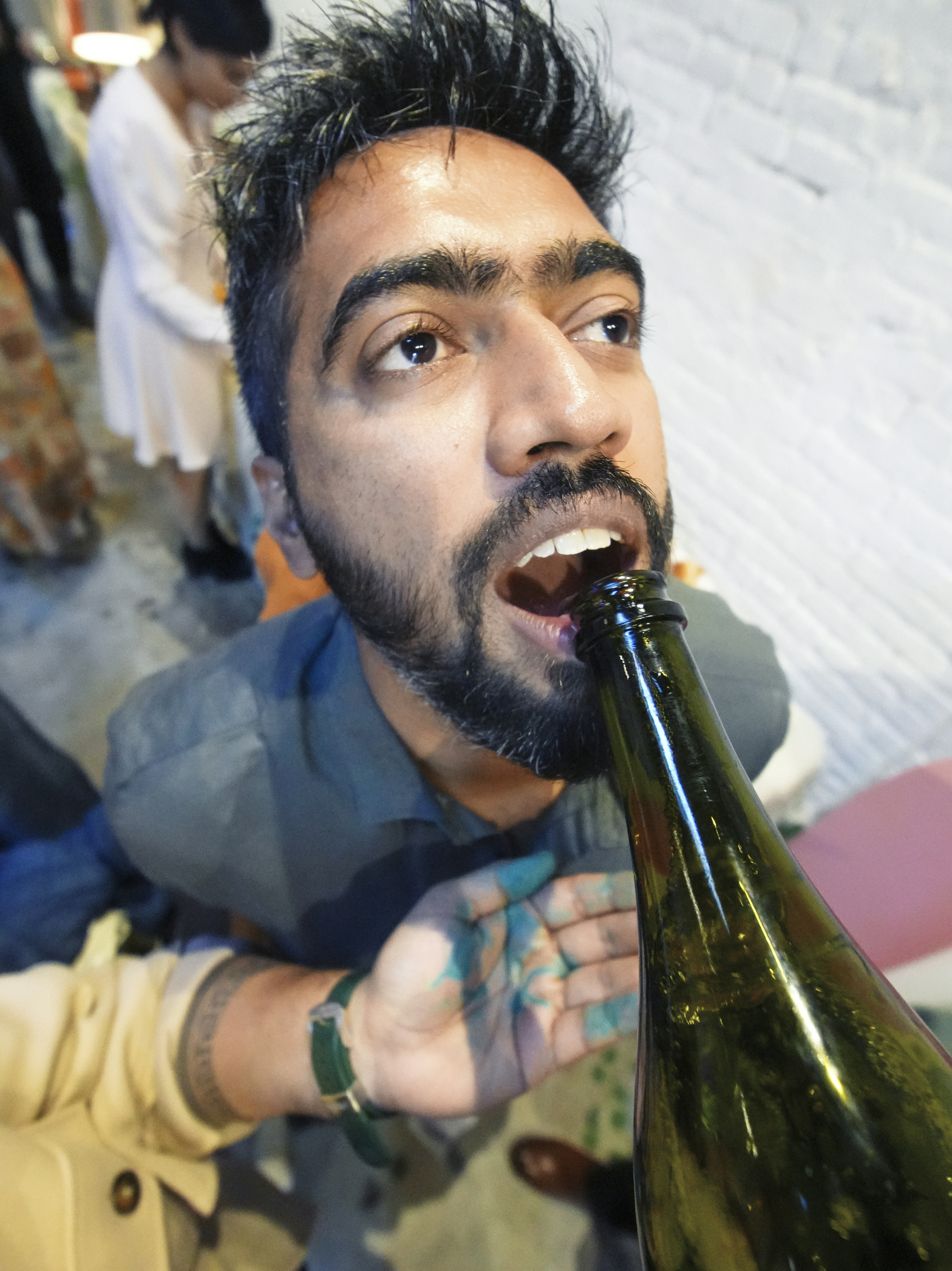 El hombre bebe directamente de una gran botella verde