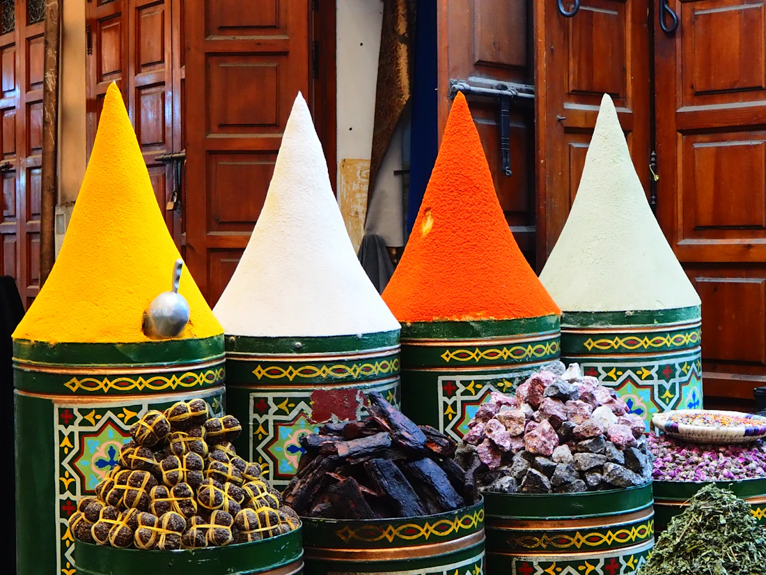 Cones of brightly coloured spices on display at a market stall in a Moroccan souk