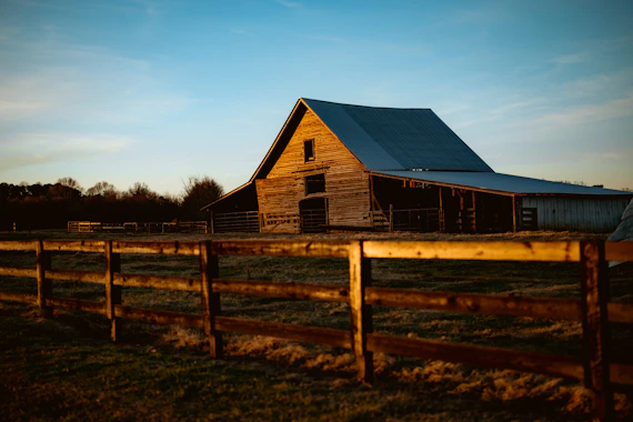Wooden barn with fence in golden hour light