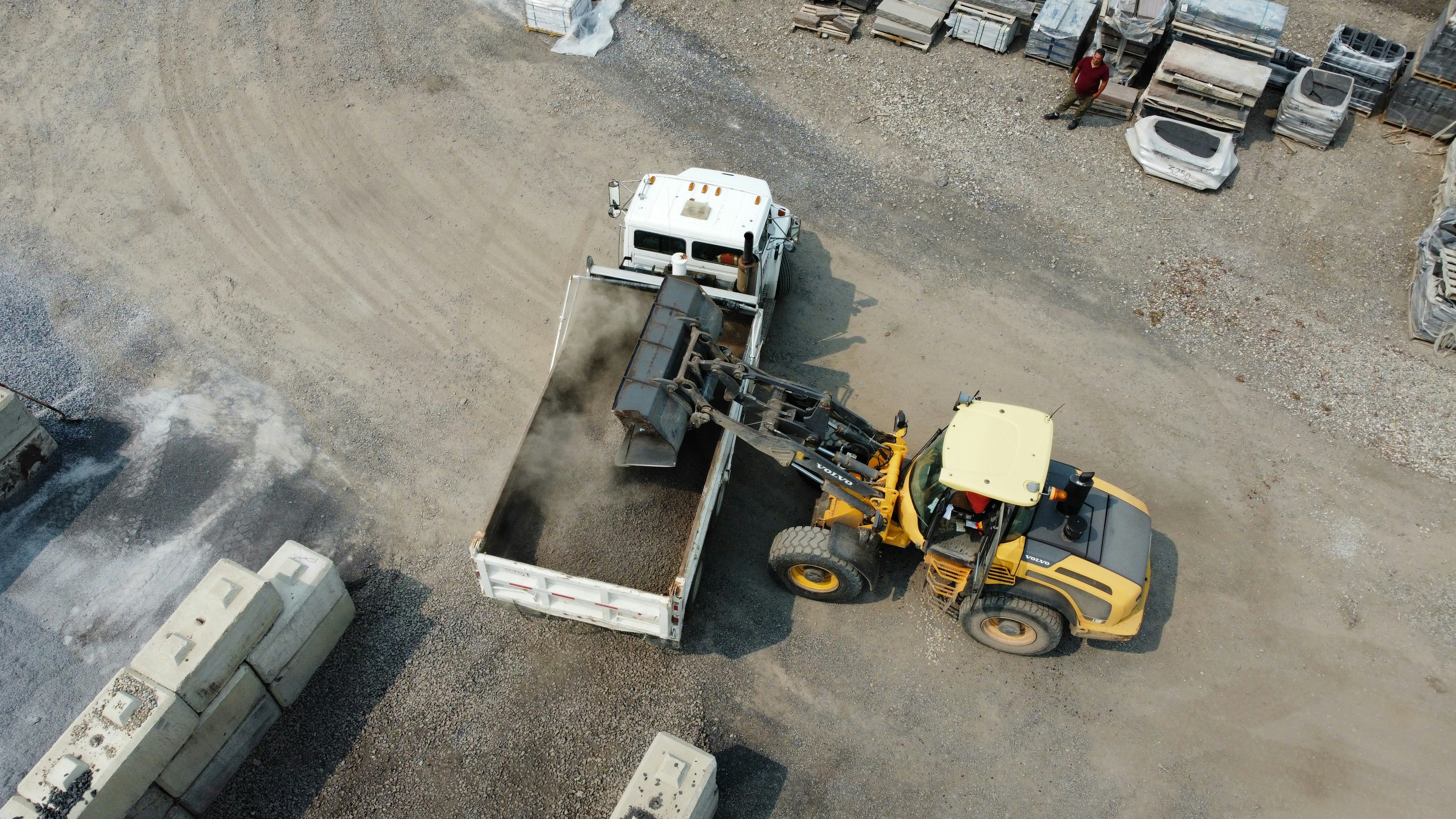 Front loader dumping material into a truck
