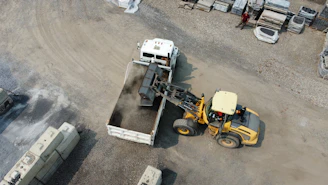 Front loader dumping material into a truck
