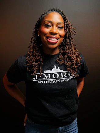 A woman with dreadlocks wearing a black t-shirt.