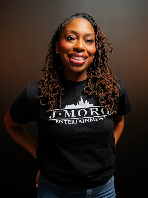 A woman with dreadlocks wearing a black t-shirt.