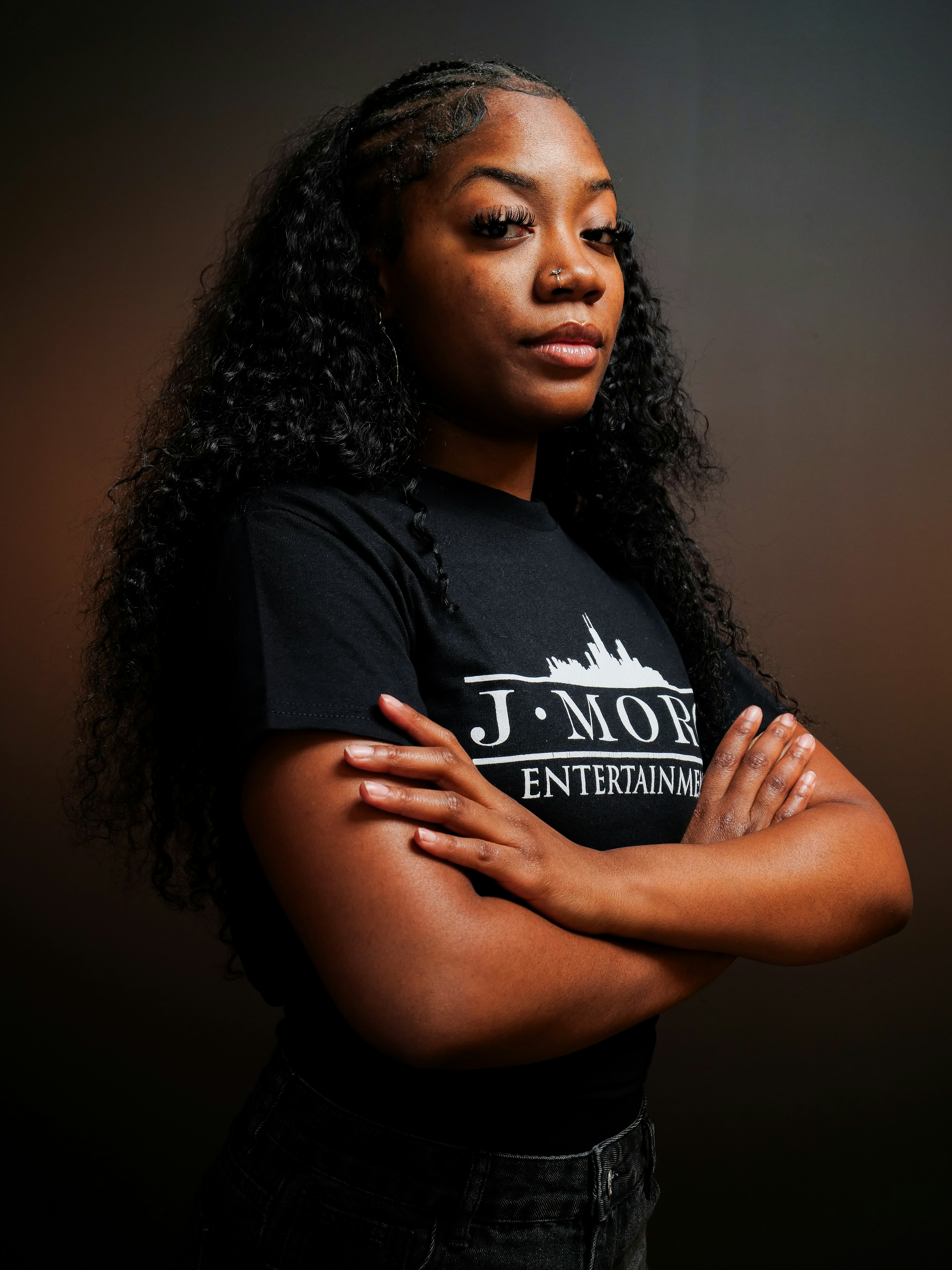 A young black woman with braided hair and arms crossed