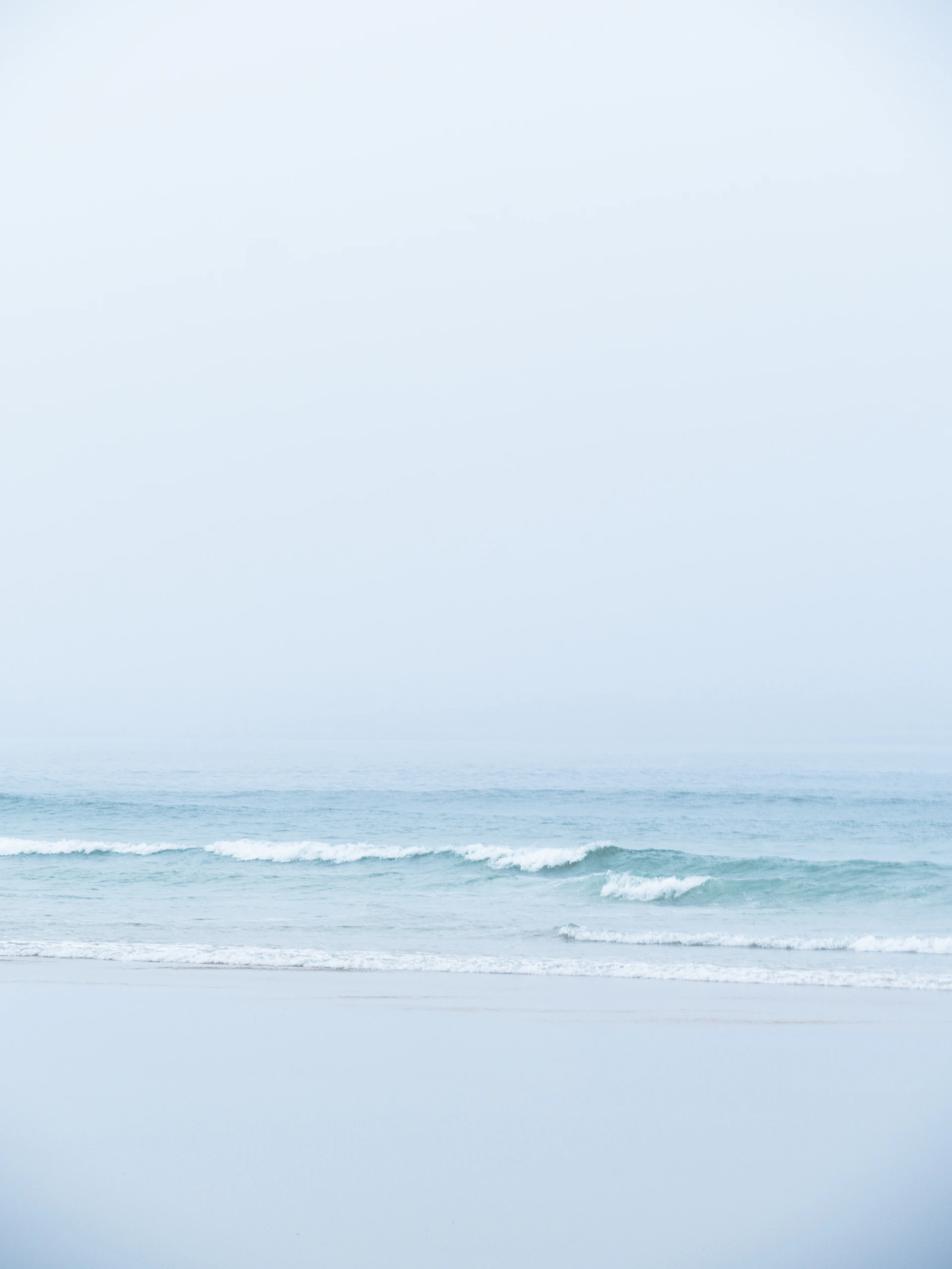 Calm ocean waves gently rolling onto a sandy shore