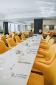 Long dining table set with yellow chairs in a restaurant