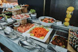 Buffet spread with pizzas, sushi, salads, and fruit