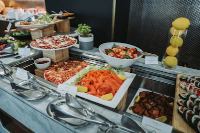 Buffet spread with pizzas, sushi, salads, and fruit