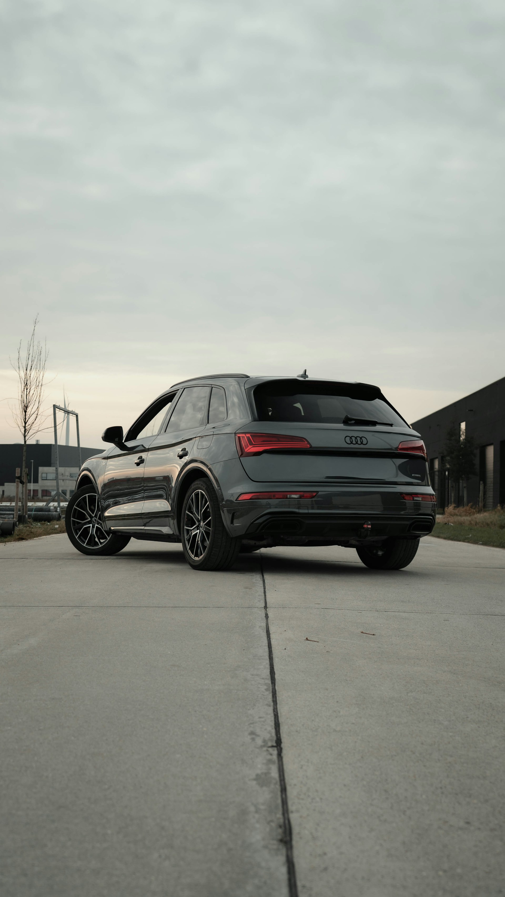 A dark grey audi suv parked on a concrete surface.