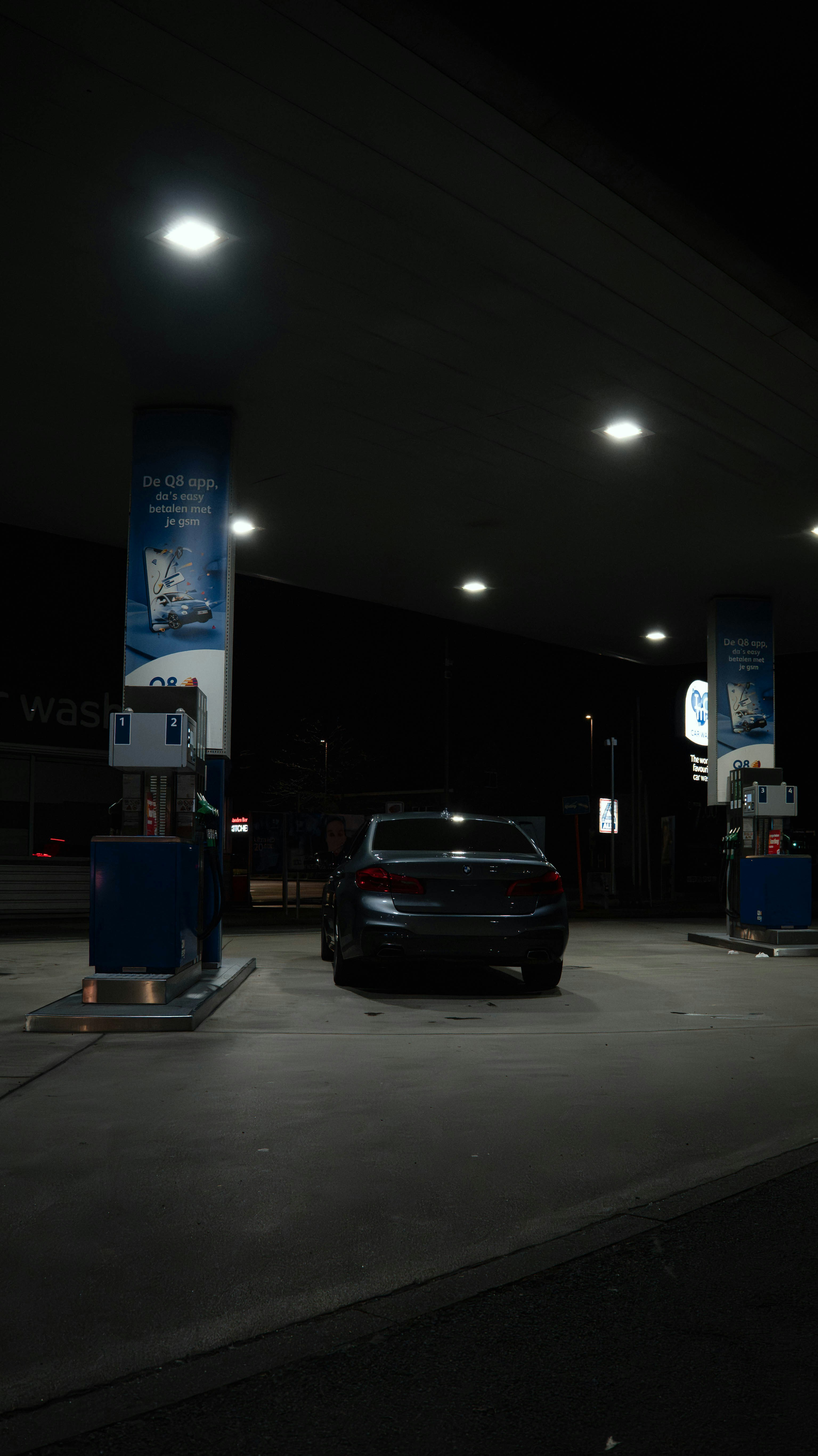 Un coche en una gasolinera por la noche.