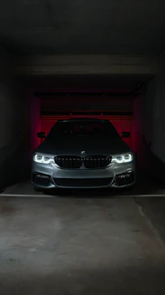 A sleek gray BMW parked in a dimly lit garage.