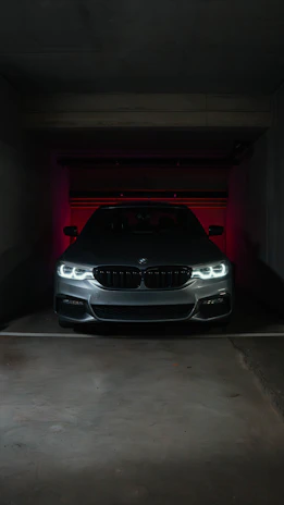 A sleek gray BMW parked in a dimly lit garage.