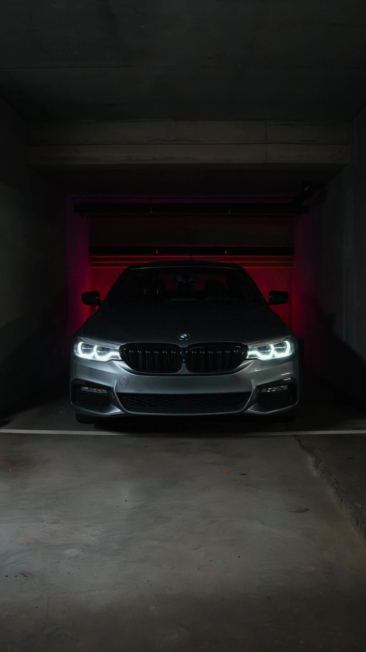 Sleek gray BMW parked in a dimly lit garage showcasing glossy paint finish