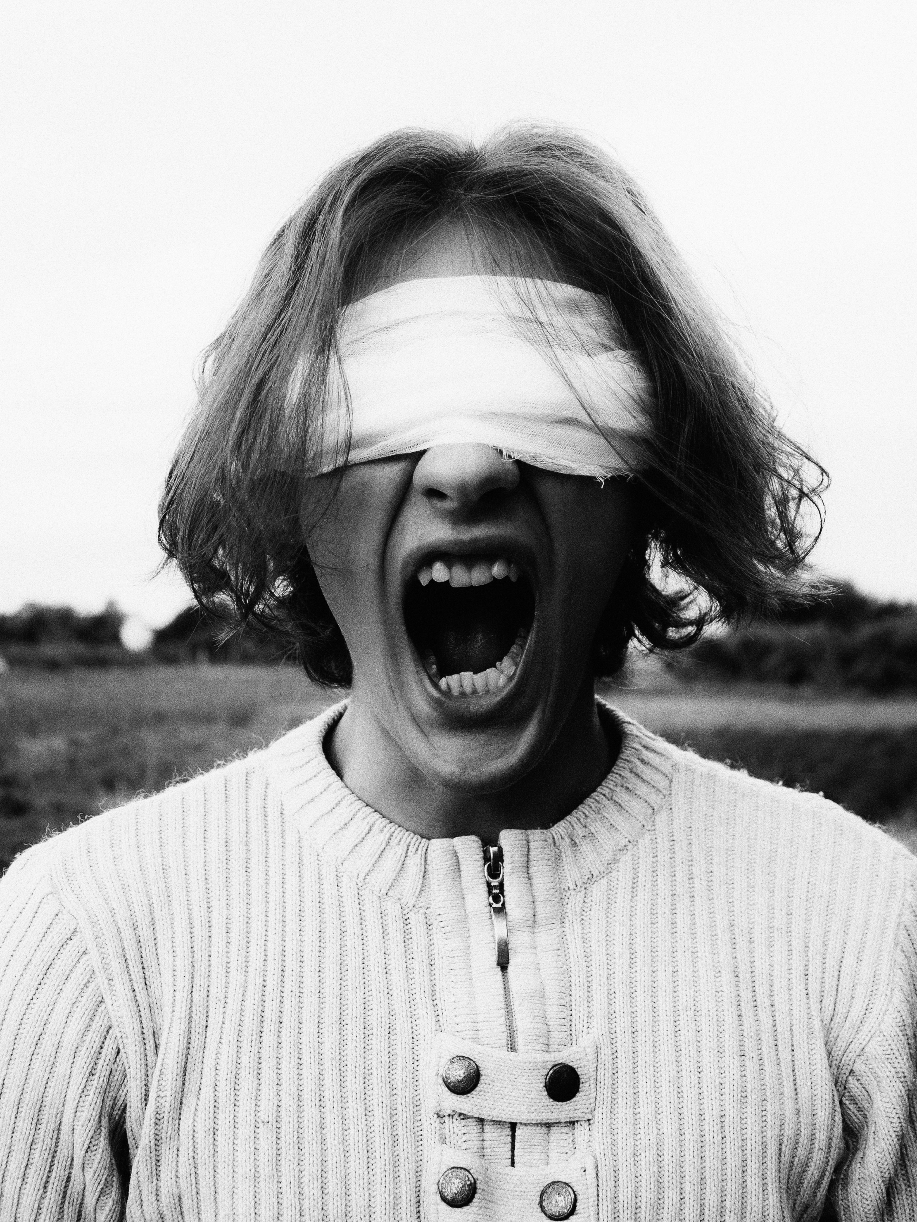 Eine Person mit bedeckten Augen, die vor Not schreit