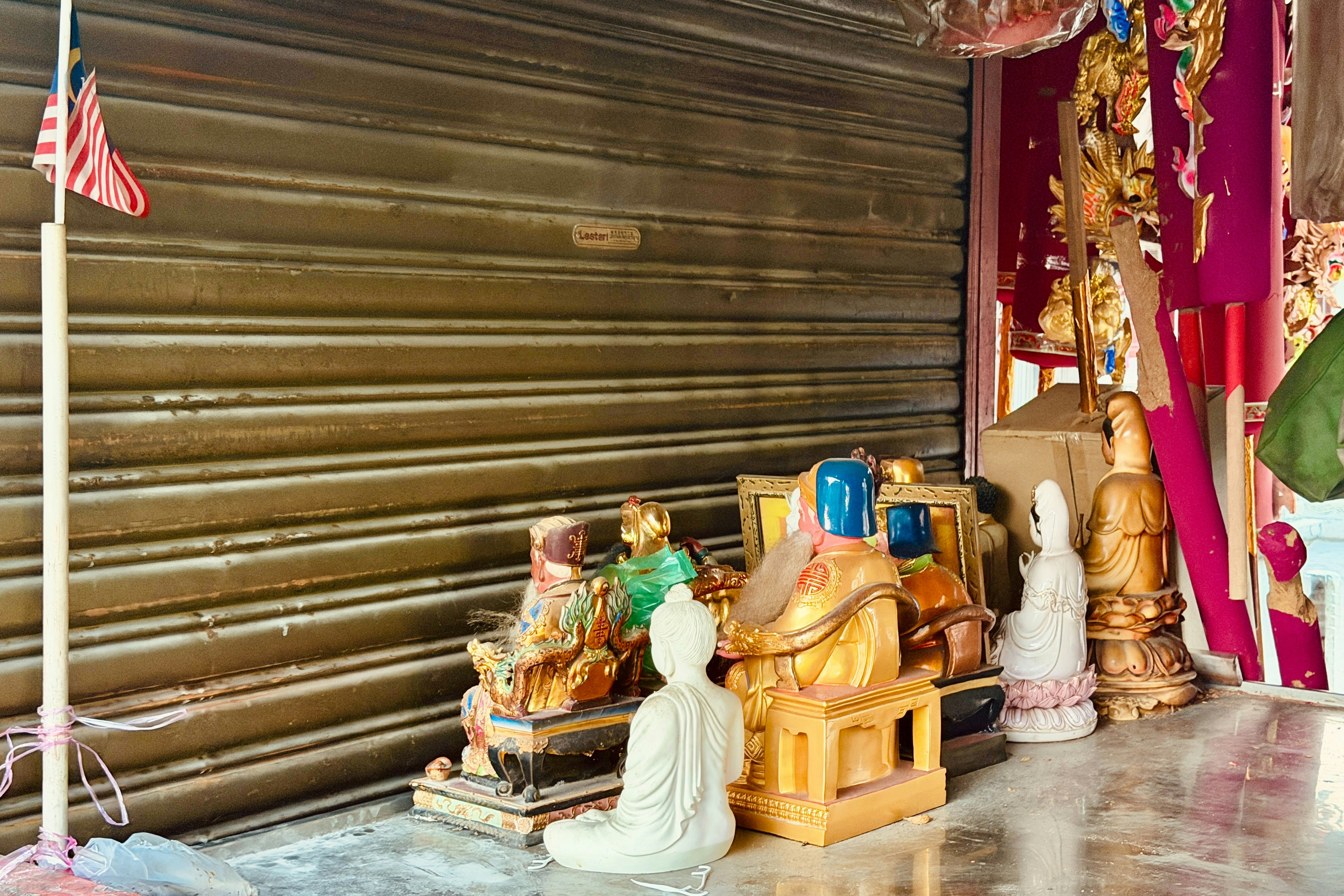 Small statues of deities displayed outside a shop.