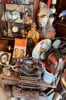 Collection of vintage items including typewriter and buddha statue
