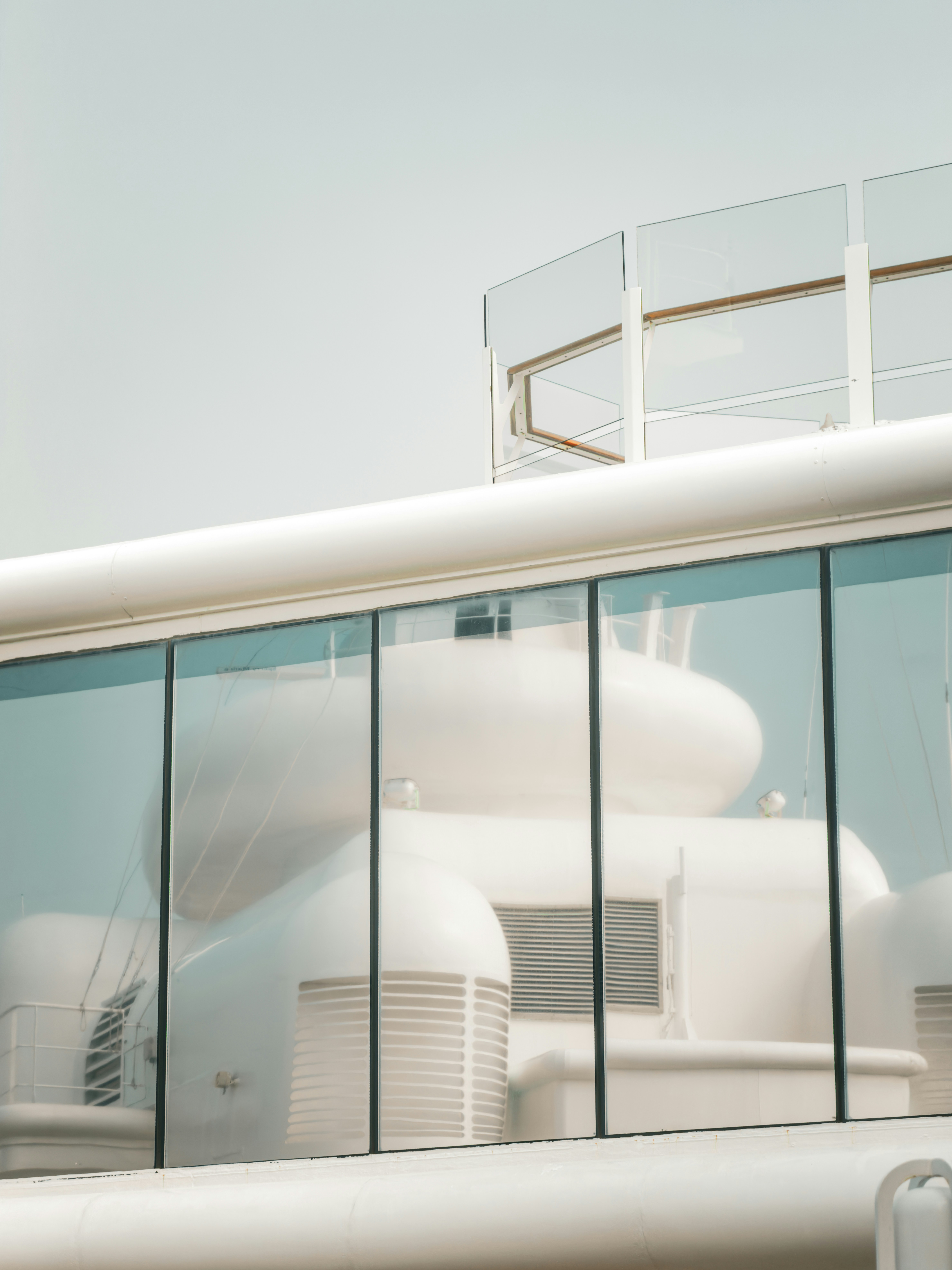 Modern white structure with glass windows reflecting sky