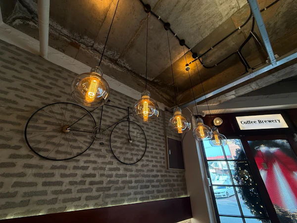 Edison filament bulbs hanging over exposed brickwork at the Hive Workspace entrance