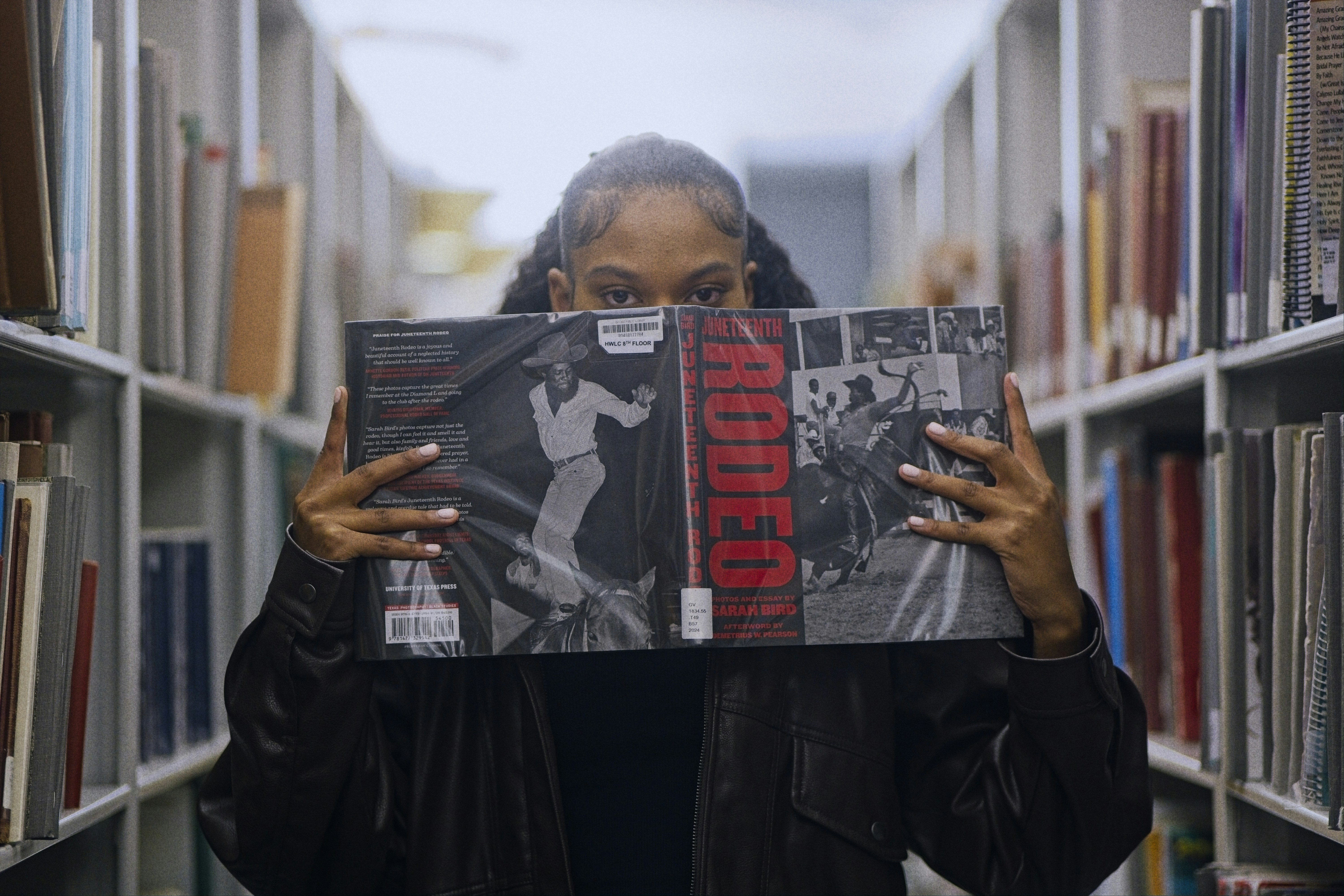 Frau hält ein Plattenalbum in einer Bibliothek