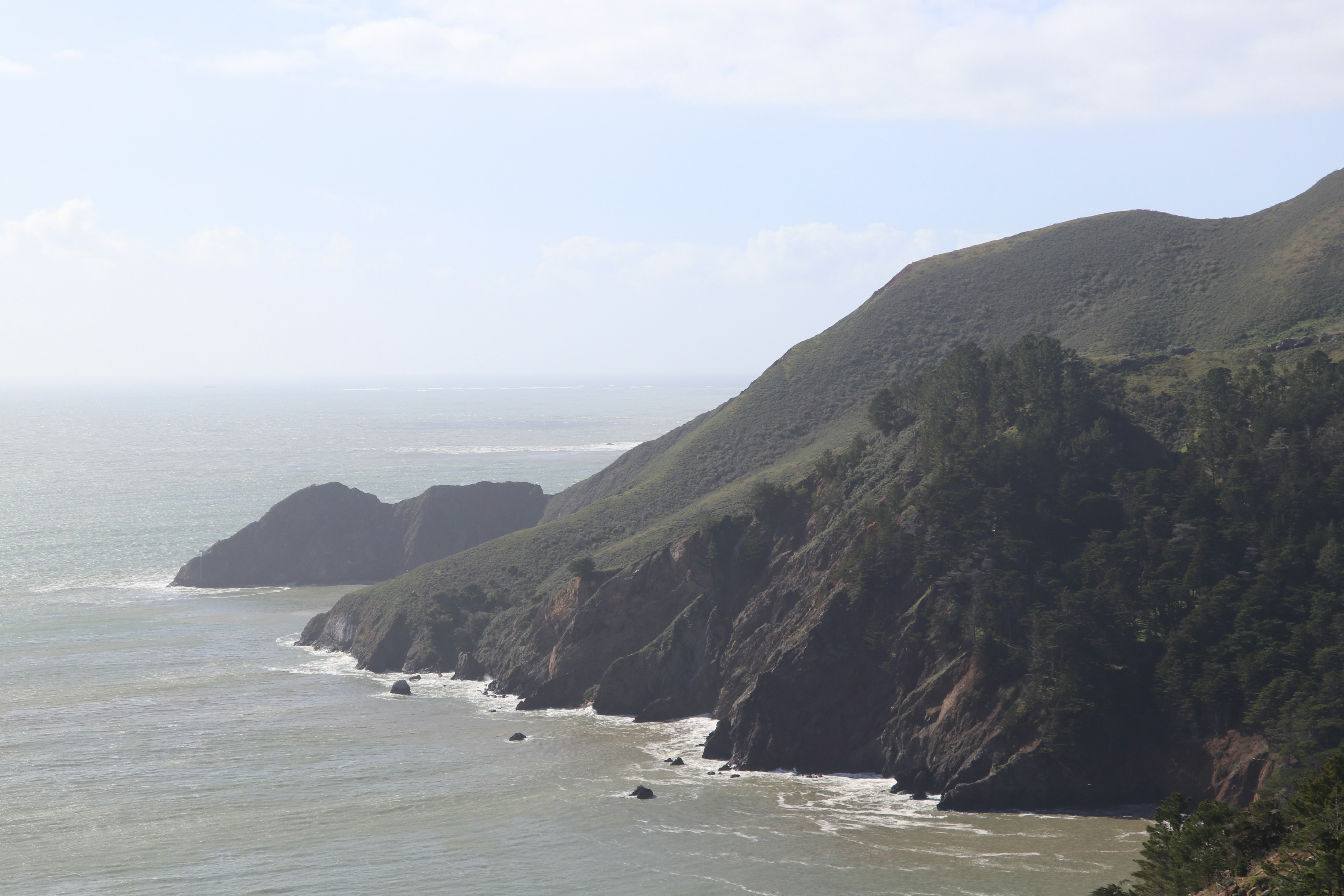 Rugged coastline with waves crashing against cliffs.