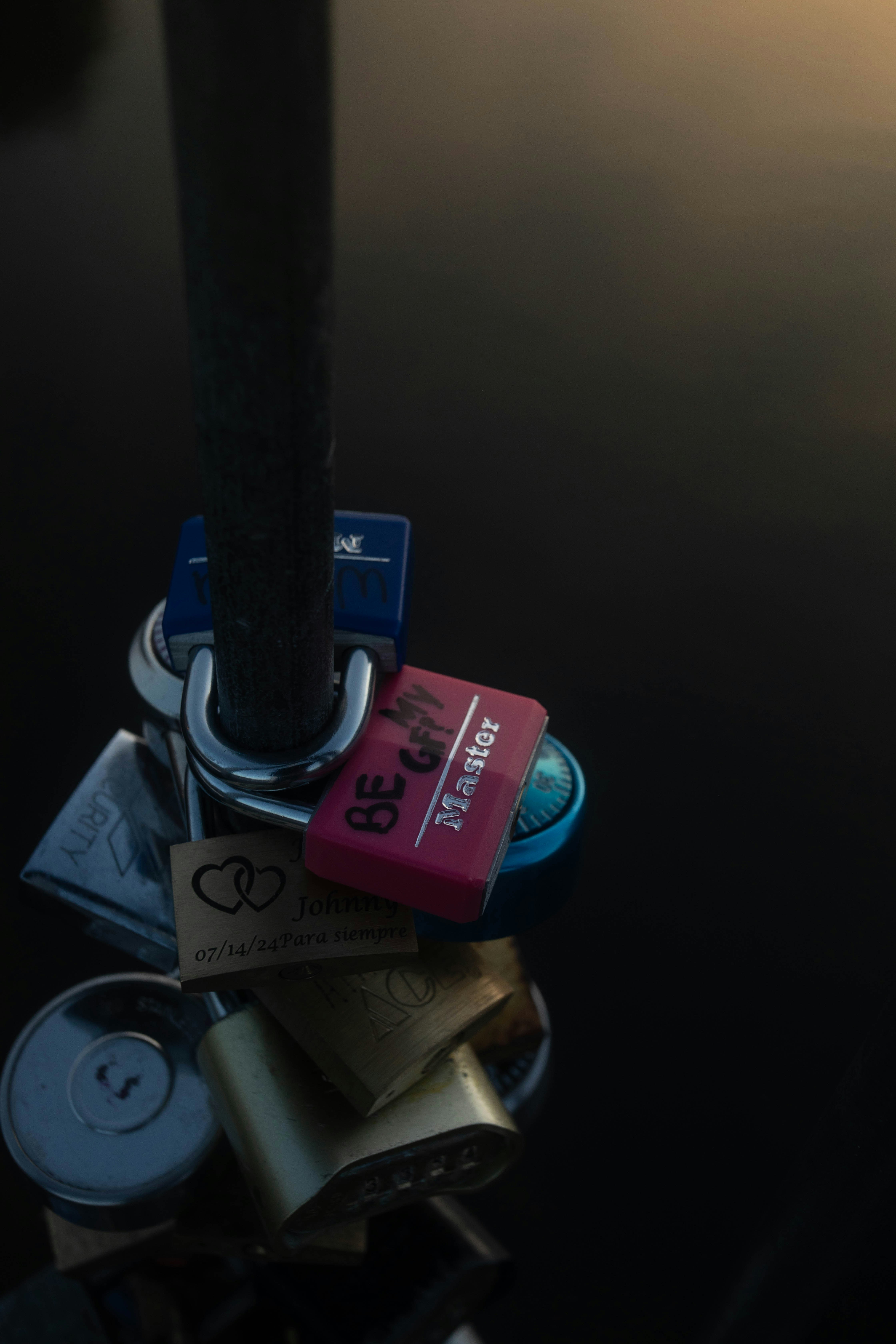 Love locks attached to a metal pole over water