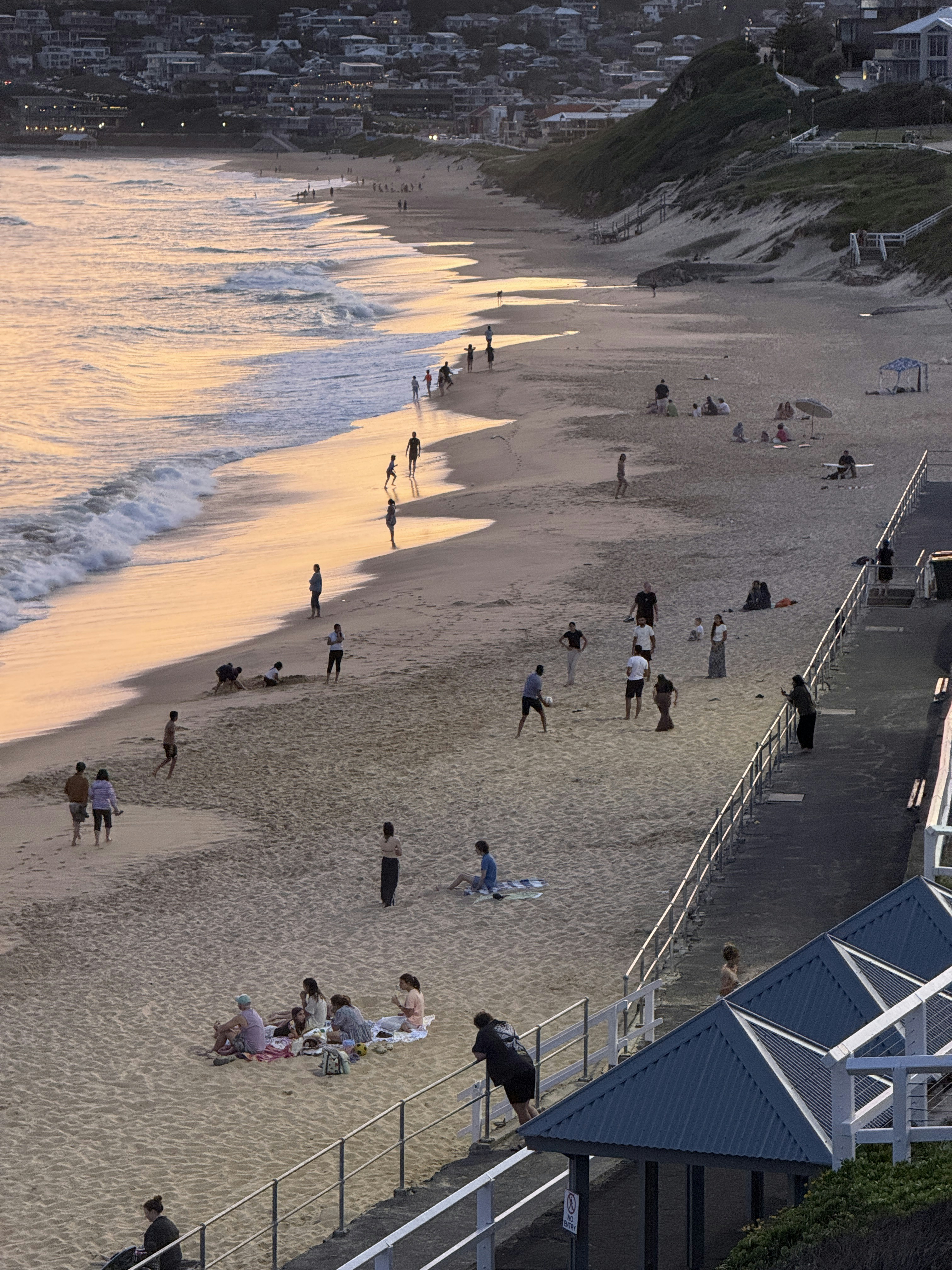 People relaxing on a sandy beach at sunset