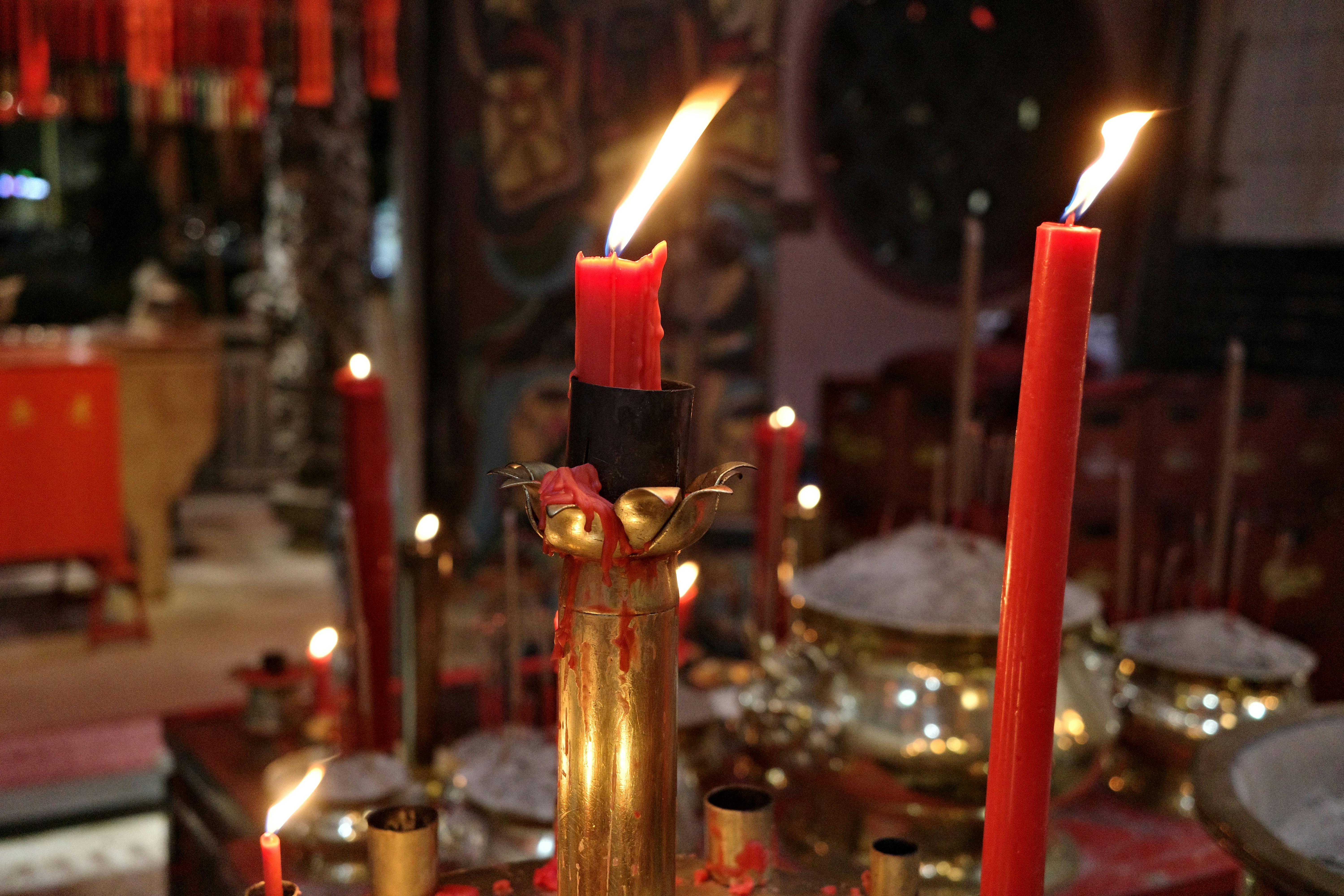 Red candles burning in a dimly lit room.