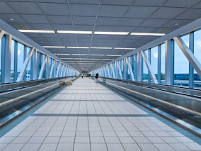 Modern airport walkway with glass walls and moving walkway