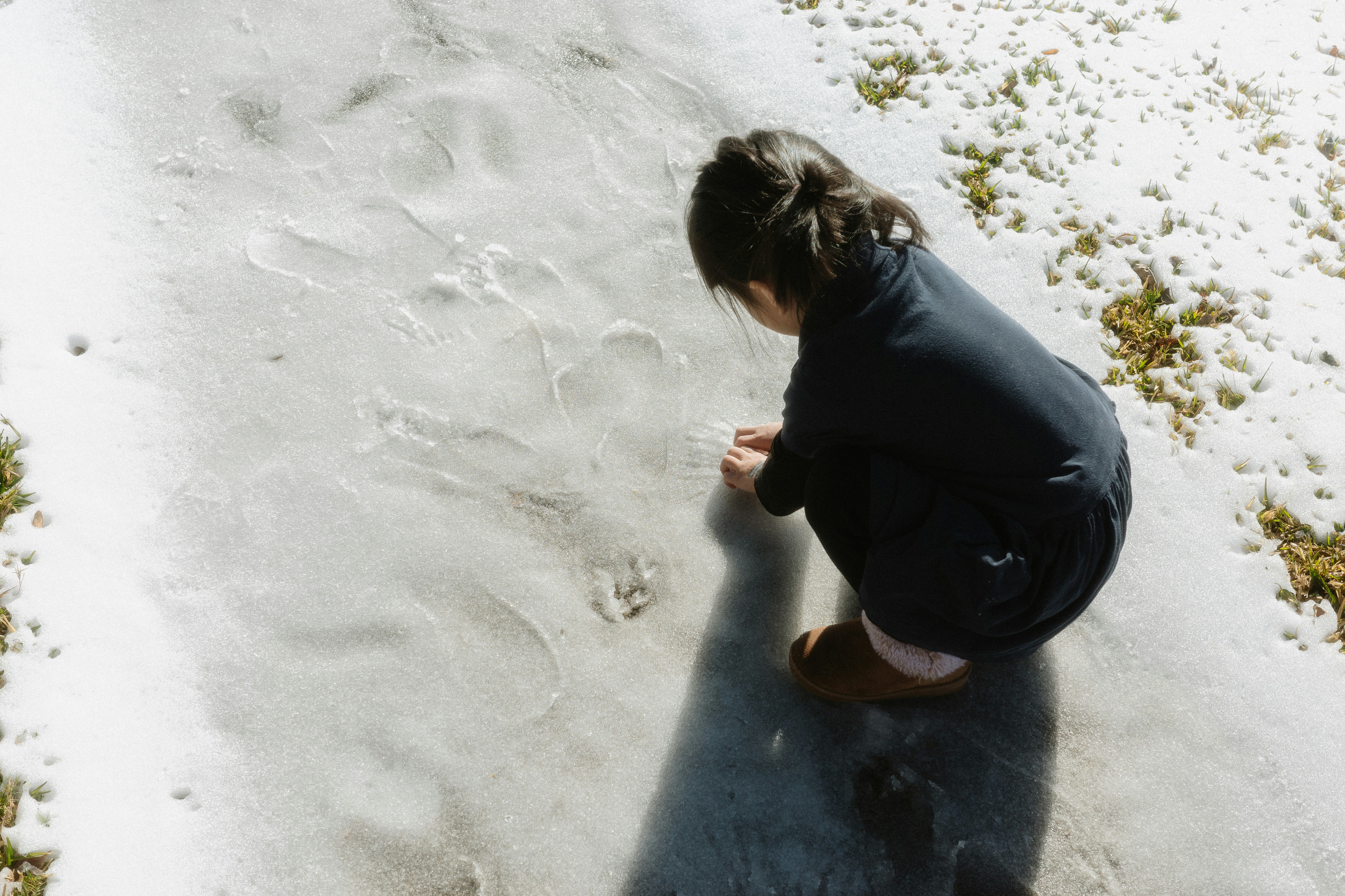Un enfant dessinant dans la neige qui fond