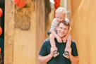 Father carrying his son on his shoulders.