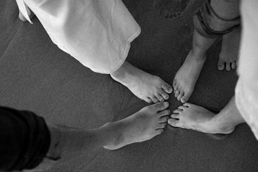 Bare feet touching in a circle on sand