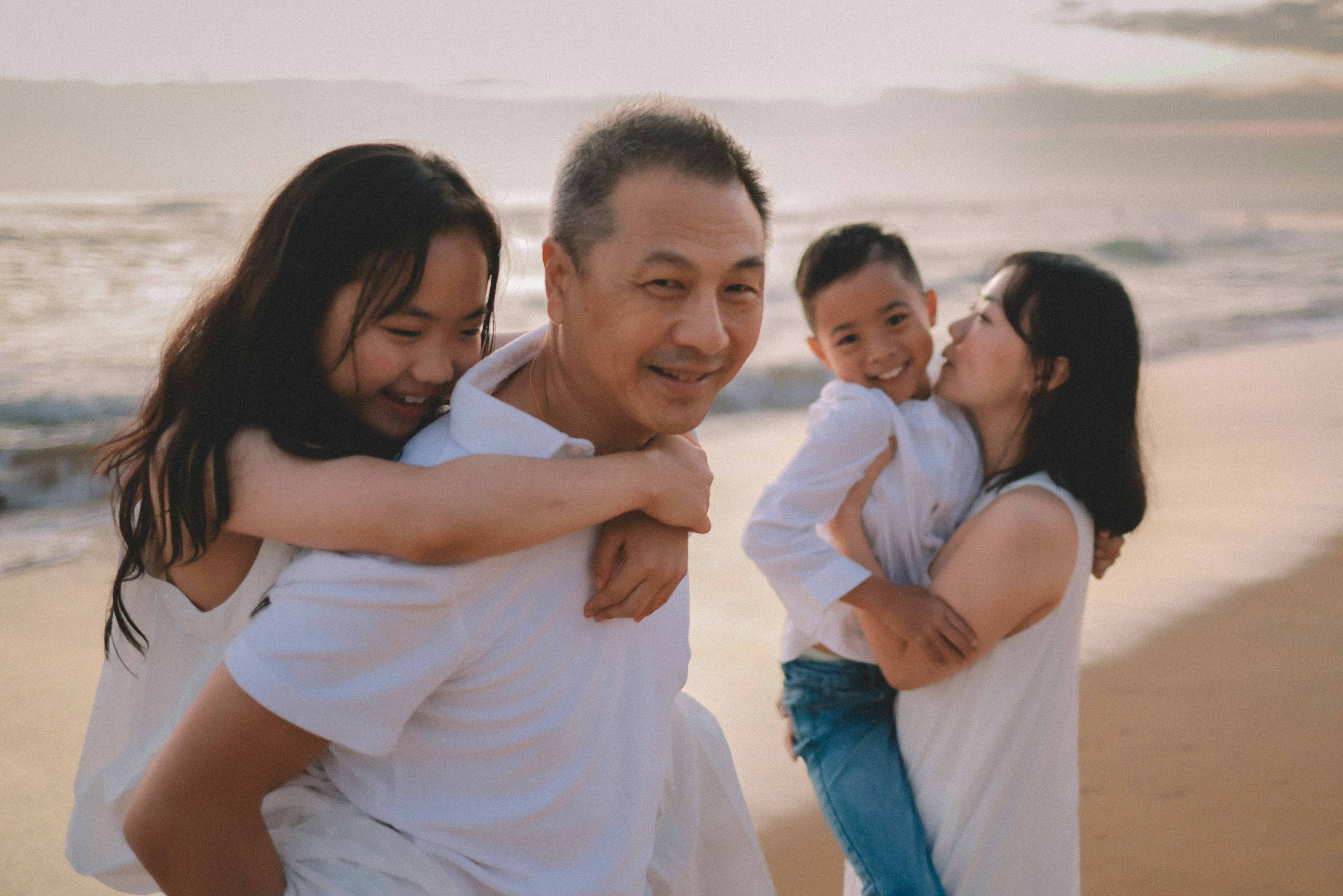 A happy family enjoys a beach at sunset