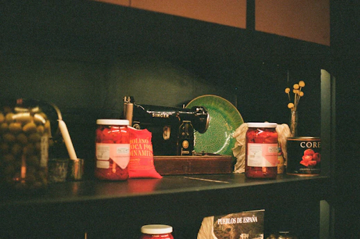 Jars of food and a sewing machine on a shelf
