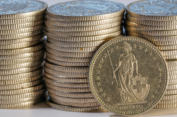 Stacks of gold coins with one coin in front
