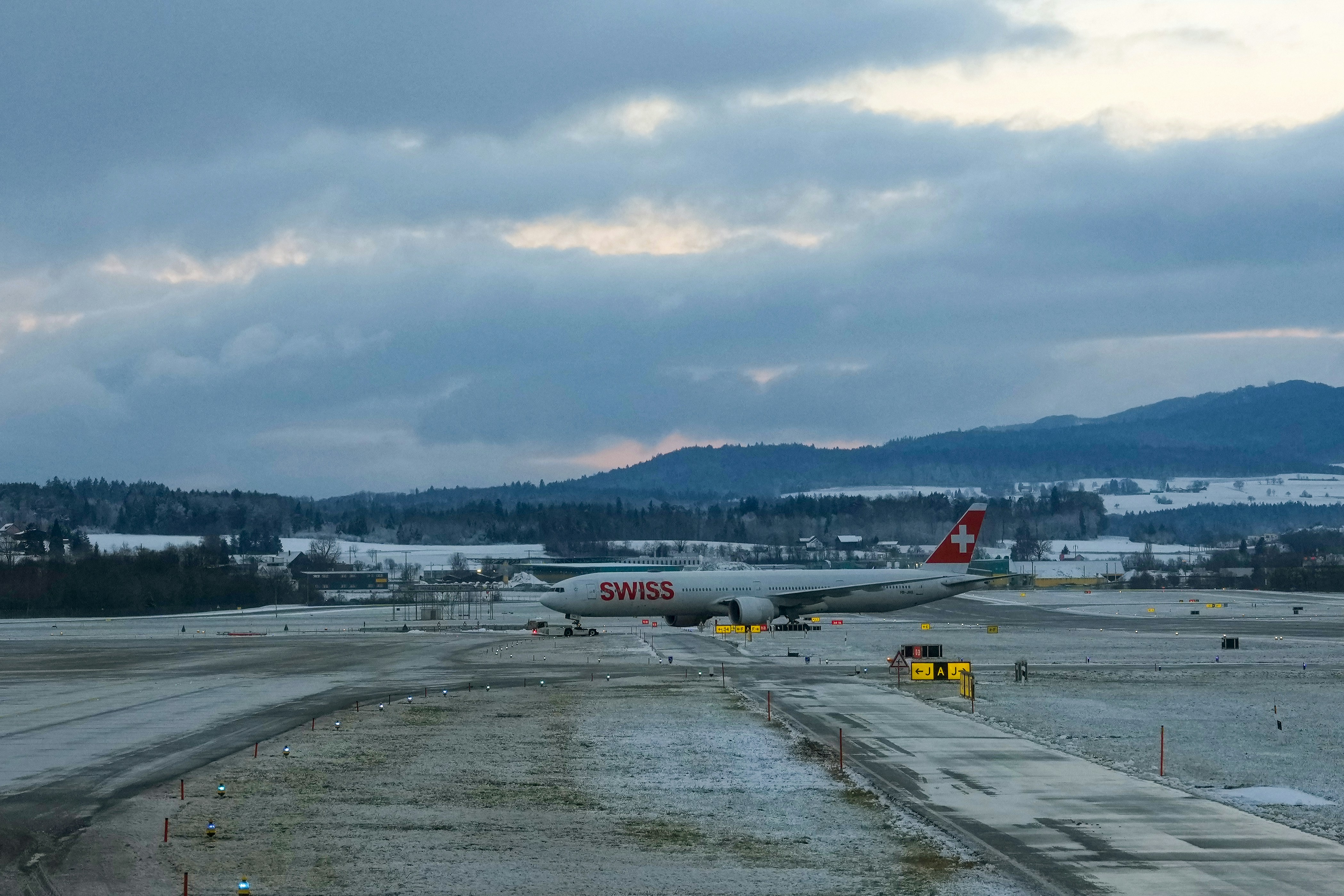 Airplane on a snowy runway under cloudy skies