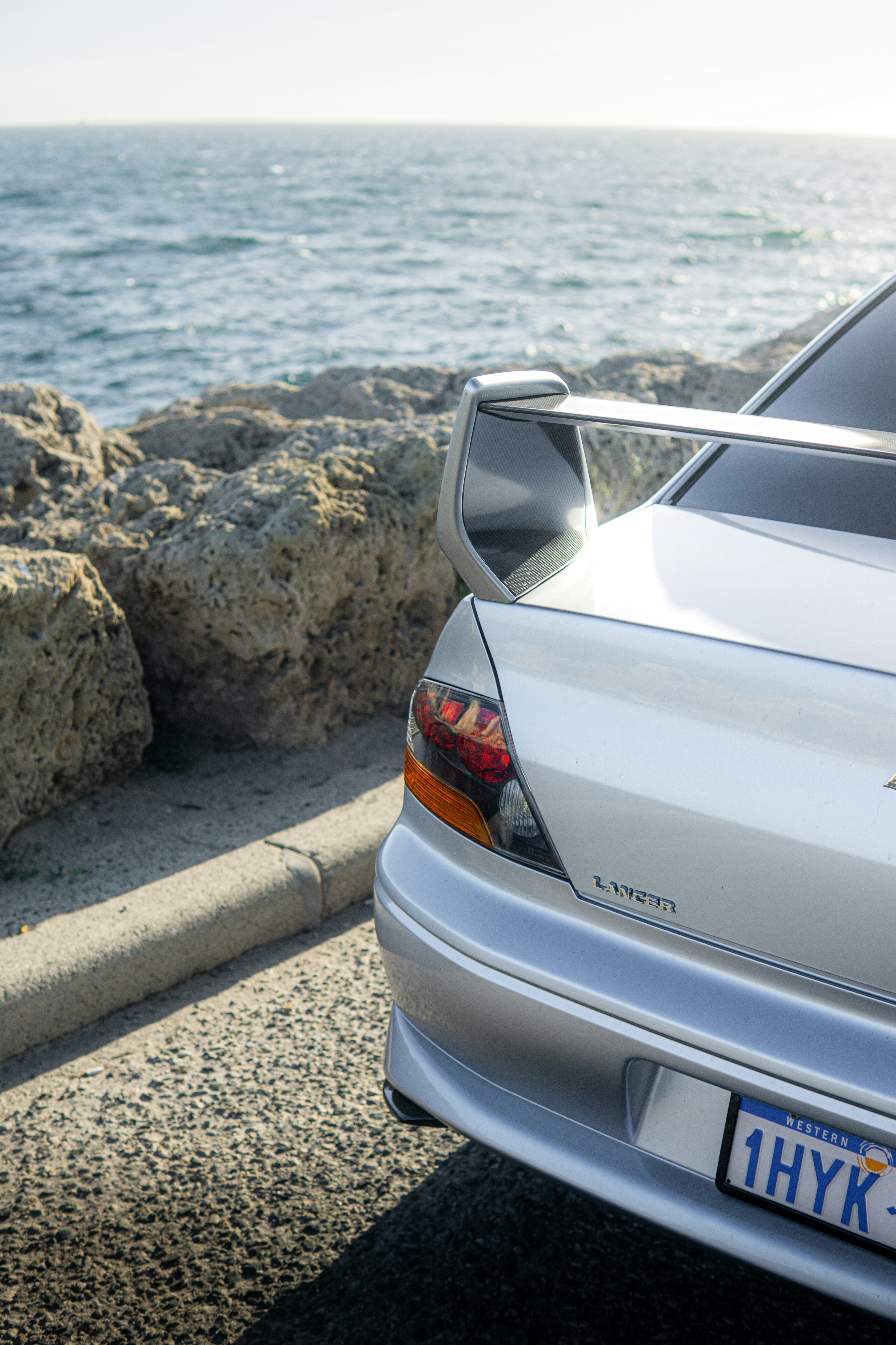Silver sports car parked by the ocean