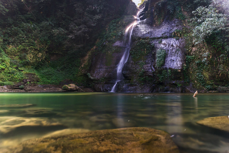 Tall waterfall descending into a forest pool in Mizoram