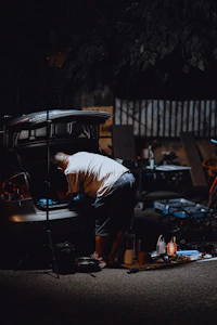 Man loading items into car trunk at night