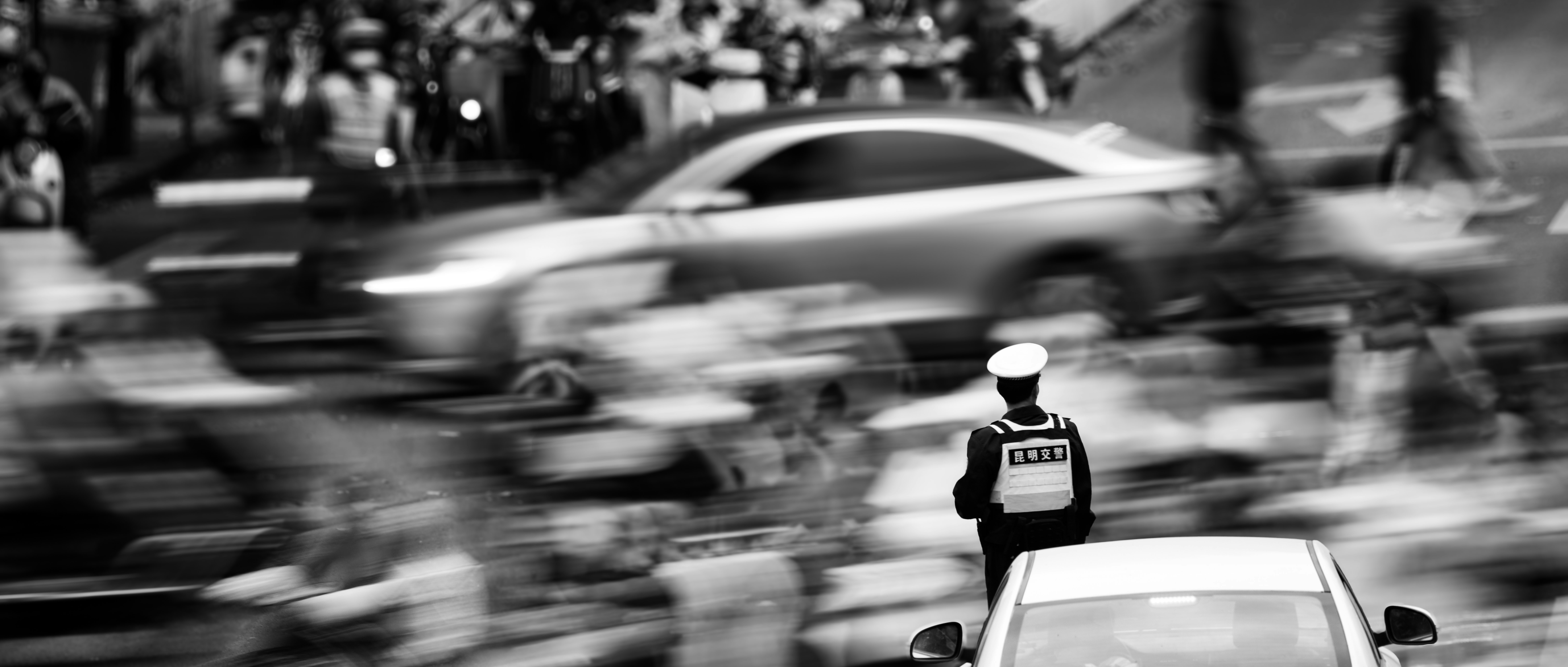 Agent de la circulation dirigeant les voitures dans une rue très fréquentée.