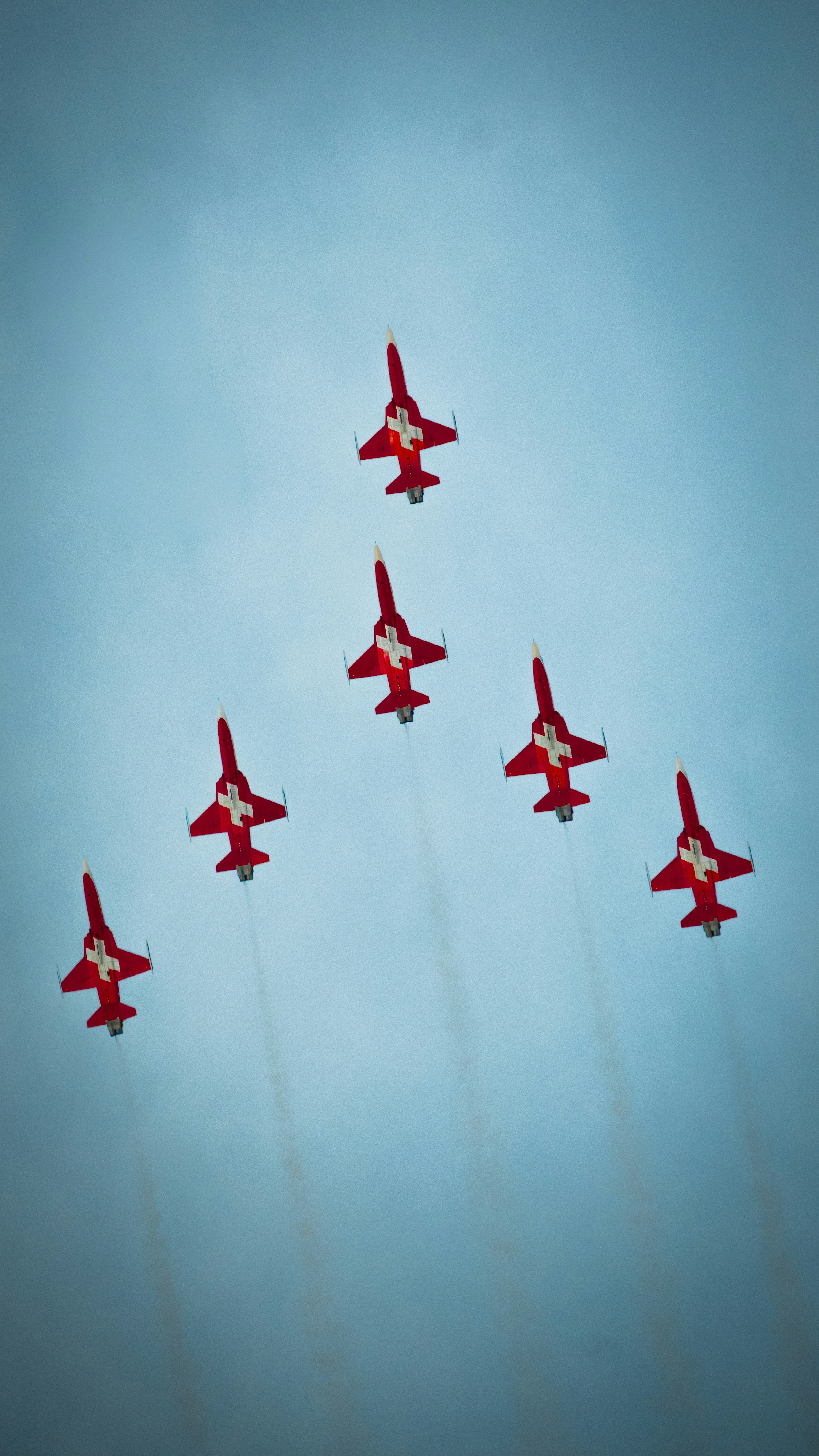 Seven red fighter jets fly in formation